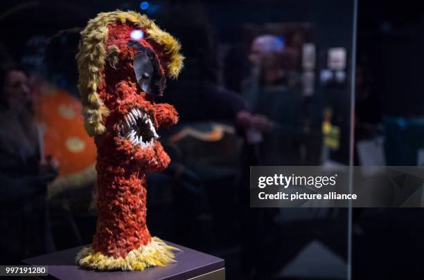 Visitors walking past an 18th century feather figure of the war god Kuka'ilimoku during a press tour of the exhibition "Hawai'i - Royal Island in the...