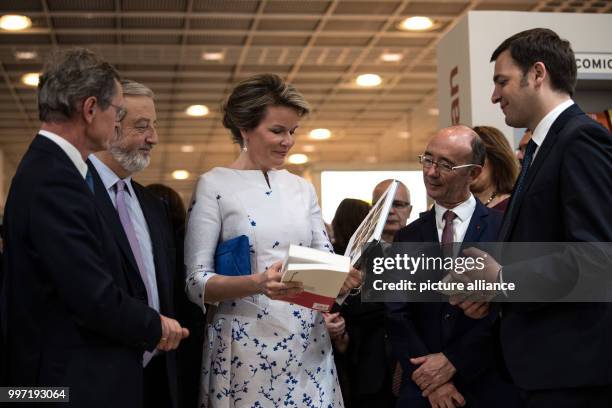 Queen Mathilde of Belgium visits the Frankfurt Book Fair and takes a look at a book in Frankfurt, Germany, 12 October 2017. Photo: Fabian Sommer/dpa