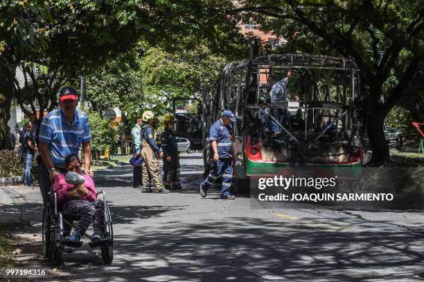 Firefighters inspect a bus set on fire by gang members near Comuna 13 neighbourhood in Medellin, Antioquia Department, Colombia, on July 12, 2018. -...