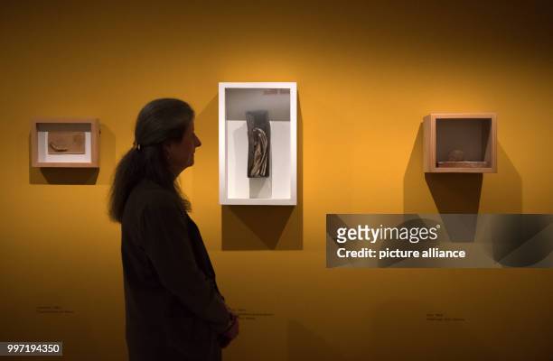 Curator Barbara Strieder stands next to an untitled work of artist Joseph Beuys in which he used a cake tin and bones as working materials in the...