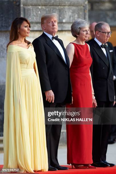 First Lady Melania Trump, US President Donald Trump, Britain's Prime Minister Theresa May, and her husband Philip May stand on the steps in the Great...