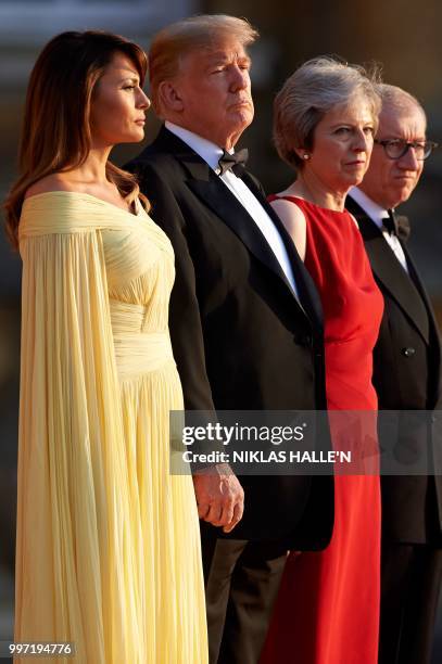 First Lady Melania Trump, US President Donald Trump, Britain's Prime Minister Theresa May, and her husband Philip May stand on the steps in the Great...