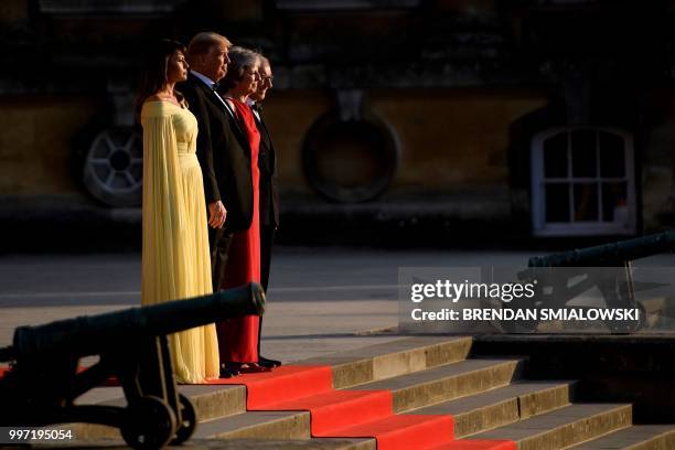 First Lady Melania Trump, US President Donald Trump, Britain's Prime Minister Theresa May, and her husband Philip May stand on the steps in the Great...