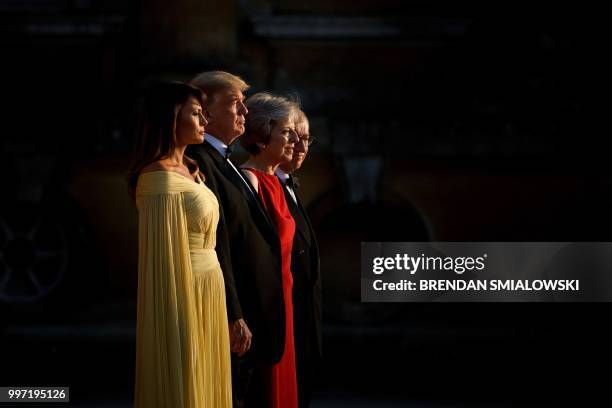 First Lady Melania Trump, US President Donald Trump, Britain's Prime Minister Theresa May, and her husband Philip May stand on the steps in the Great...