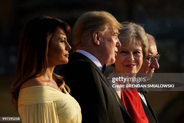 First Lady Melania Trump, US President Donald Trump, Britain's Prime Minister Theresa May, and her husband Philip May stand on the steps in the Great...