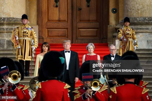 First Lady Melania Trump, US President Donald Trump, Britain's Prime Minister Theresa May, and her husband Philip May stand on the steps in the Great...