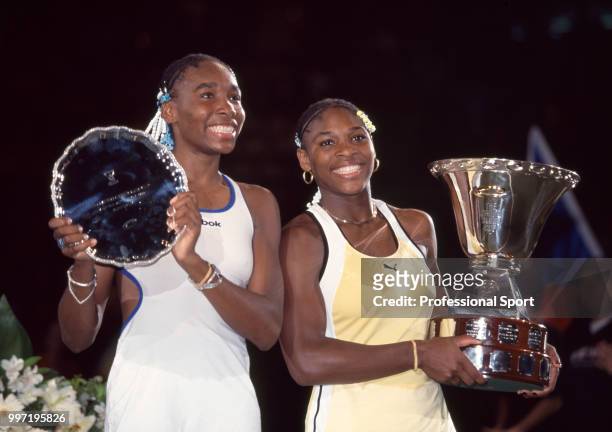 Champion Serena Williams of the USA and her sister and runner-up Venus Williams pose with their trophies after the Women's Final of the Compaq Grand...