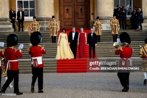 First Lady Melania Trump, US President Donald Trump, Britain's Prime Minister Theresa May, and her husband Philip May stand on the steps in the Great...