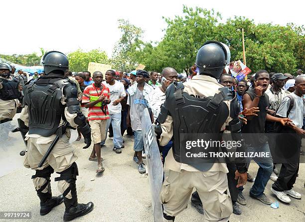 Haitians march past riot police as they demonstrate near the presidential palace in Port-au-Prince on May 17, 2010 against President Rene Preval's...