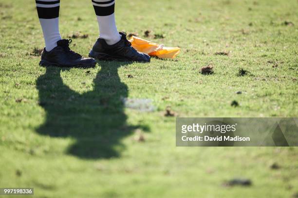 american football referee standing next to penalty flag - penalty flag stock pictures, royalty-free photos & images