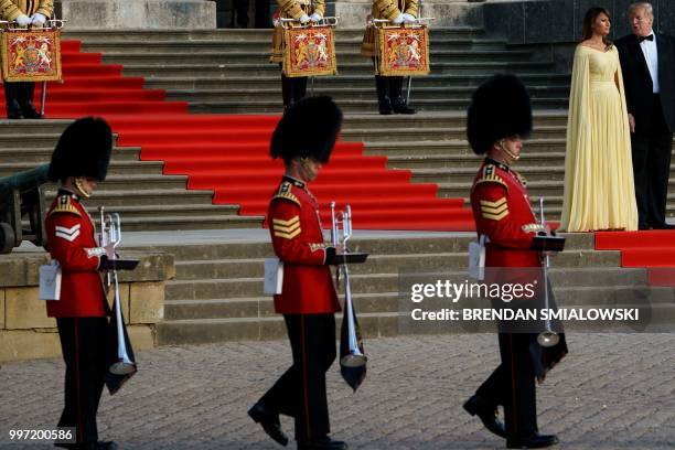 First Lady Melania Trump and US President Donald Trump stand on the steps in the Great Court to watch the bands of the Scots, Irish and Welsh Guards...