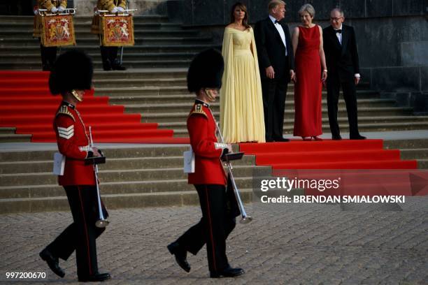 First Lady Melania Trump, US President Donald Trump, Britain's Prime Minister Theresa May, and her husband Philip May stand on the steps in the Great...