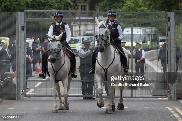 Mounted police officers leave the temporary perimeter fence encircling Winfield House, the official residence of the US Ambassador during the visit...