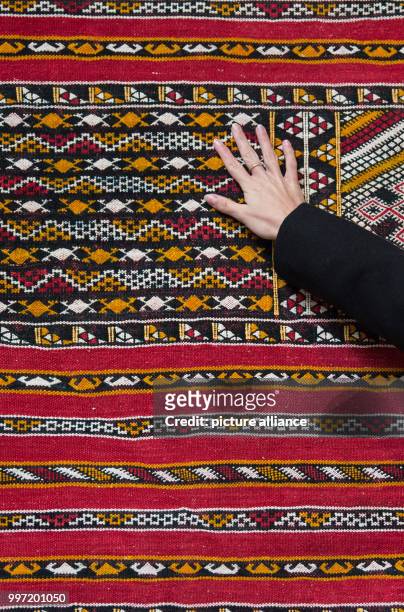 Model Louisa touches a Moroccan carpet of a Berber tribe during a pre-tour of the event and sales trade show 'infa' in Hanover, Germany, 13 October...