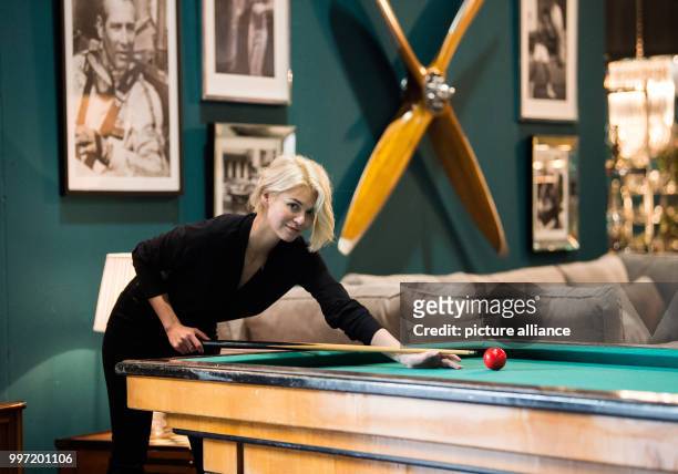 Model Louisa plays on a pool table from 1890 during a pre-tour of the event and sales trade show 'infa' in Hanover, Germany, 13 October 2017. 1.400...