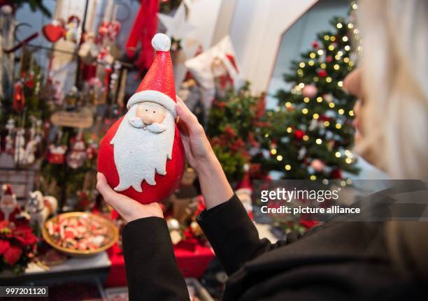 Model Louisa takes a look at a Santa Claus figure during a pre-tour of the event and sales trade show 'infa' in Hanover, Germany, 13 October 2017....