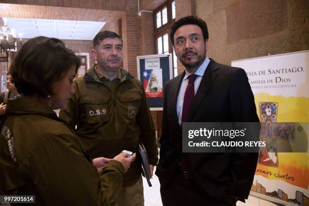 Regional prosecutor Emiliano Arias , stands next to police officers at the Archbishopric of Santiago, on July 12 after requesting the arrest warrant...