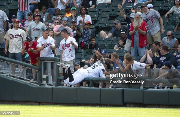 Avisail Garcia of the Chicago White Sox dives into the stands while catching a baseball hit by Brian Dozier of the Minnesota Twins on June 28, 2018...