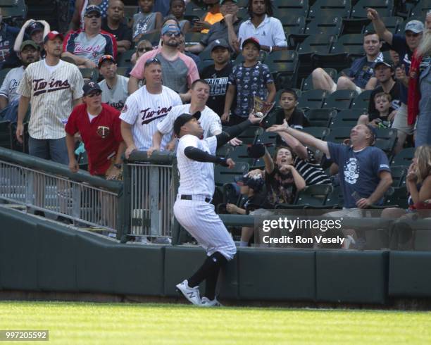 Avisail Garcia of the Chicago White Sox dives into the stands while catching a baseball hit by Brian Dozier of the Minnesota Twins on June 28, 2018...