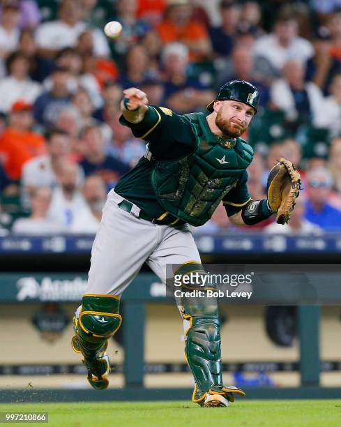 Jonathan Lucroy of the Oakland Athletics throws to first base to retire Marwin Gonzalez of the Houston Astros in the fourth inning at Minute Maid...