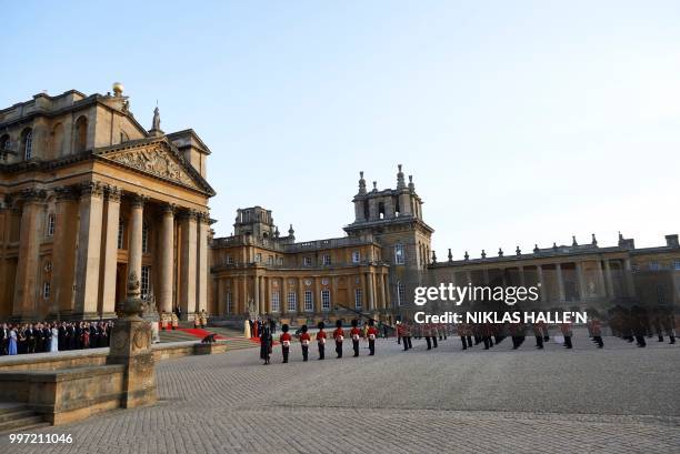 First Lady Melania Trump, US President Donald Trump, Britain's Prime Minister Theresa May, and her husband Philip May stand on the steps in the Great...