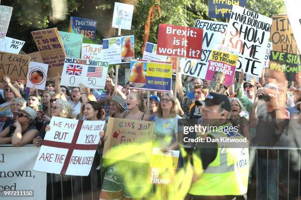 Protesters seen from a coach window hold up placards along the route at Blenheim Palace prior the arrival of U.S. President Donald Trump and First...