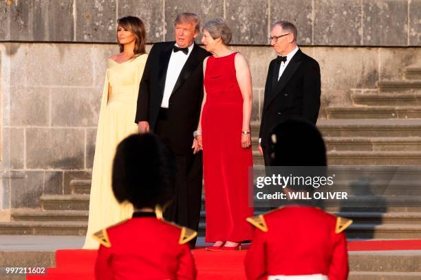 First Lady Melania Trump, US President Donald Trump, Britain's Prime Minister Theresa May and her husband Philip May stand on steps in the Great...