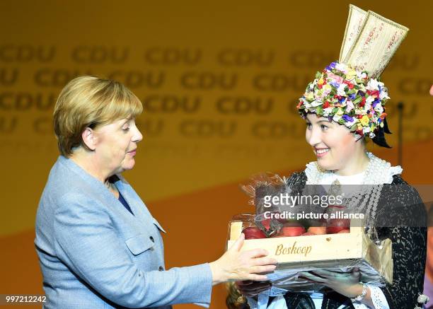 Altenland Flowerqueen Hilke Loesing presents Chancellor Angela Merkel a selection of her favourite apple Boskop at an CDU election campaign event in...