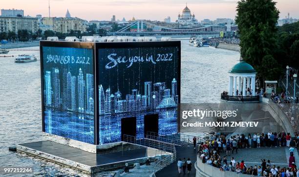 People look at the illuminated walls of Majlis Qatar pavilion in Moscow's Gorky Park in Moscow on July 12, 2018. - Qatar will host the FIFA World Cup...