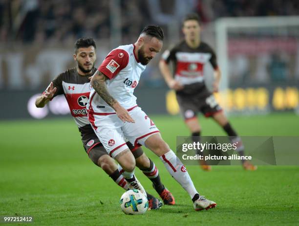 Hamburg's Cenk Sahin and Kaiserlautern's Guiliano Modica vie for the ball during the German 2nd Bundesliga soccer match between FC St. Pauli and 1st...