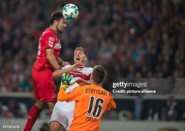 Cologne's Claudia Pizarro and Stuttgart's Simon Terodde and goalkeeper Ron-Robert Ziegler vie for the ball during the German Bundesliga soccer match...