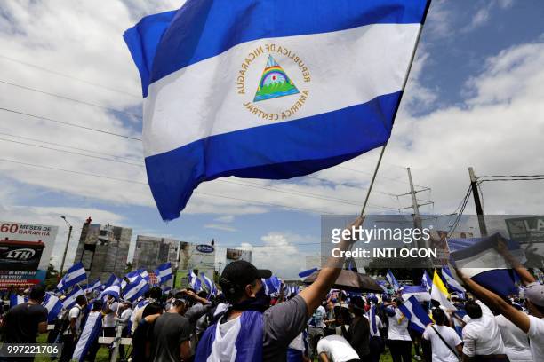 Nicaraguan opposition demonstrator holds a national flag, as he takes part in a nationwide march called "United we are a volcano" in Managua on July...