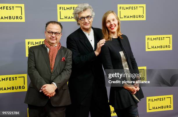 German film director Wim Wenders , the festival director Albert Wiederspiel and Wender's wife Donata stand together on arrival for the...