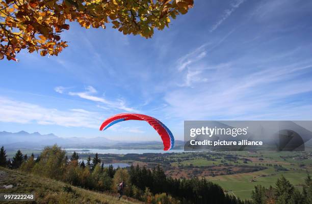 Paraglider takes off from the Buchenberg hill near Lake Forggensee in Buching, Schwangau, Germany, 13 October 2017. Photo: Karl-Josef Hildenbrand/dpa