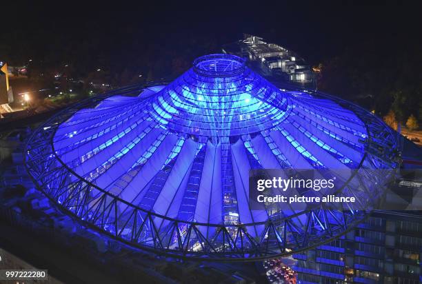 Blue light emitting from the roof of the Sony Center in Berlin, Germany, 13 October 2017. Photo: Paul Zinken/dpa