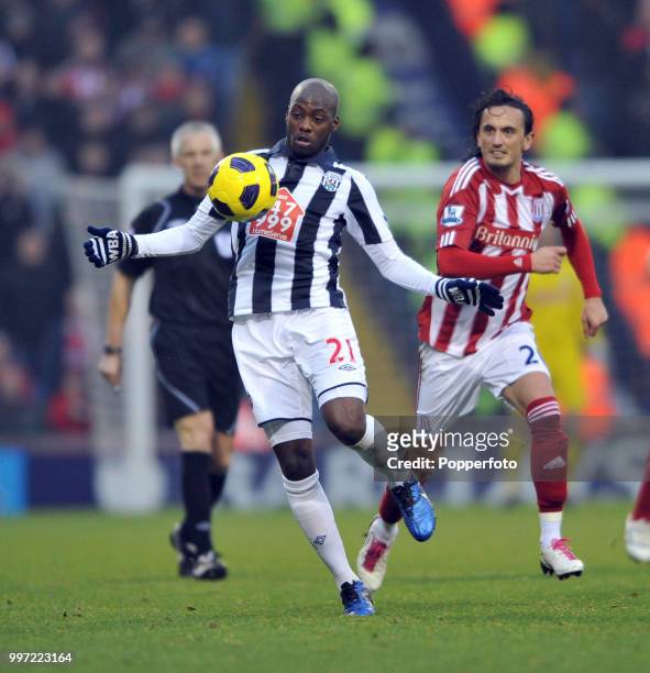 Youssouf Mulumbu of West Bromwich Albion is chased by Tuncay Sanli of Stoke City during a Barclays Premier League match at The Hawthorns on November...