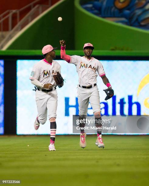 Miami Marlins outfielders Lewis Brinson and Cameron Maybin jog off the field during the third inning against the Atlanta Braves on Sunday, May 13,...