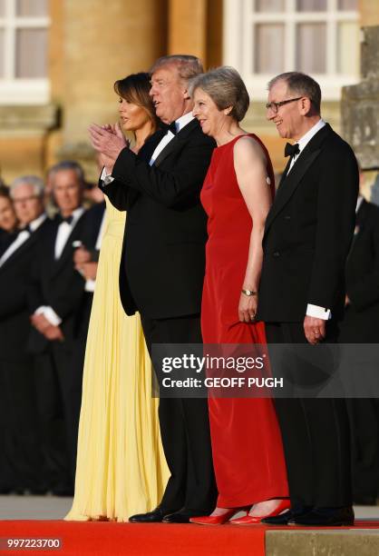 First Lady Melania Trump, US President Donald Trump, Britain's Prime Minister Theresa May and her husband Philip May stand on steps in the Great...