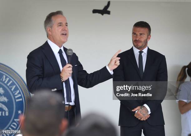 David Beckham listens as Jorge Mas addresses a rally being held next to Miami City Hall in support of building a Major League soccer stadium on July...