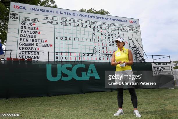 Eriko Gejo of Japan stands in front of the leader board during the first round of the U.S. Senior Women's Open at Chicago Golf Club on July 12, 2018...