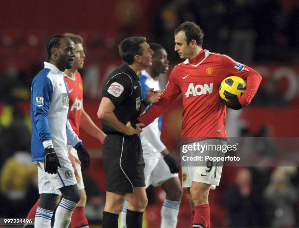 Referee Lee Probert tries unsuccessfully to reclaim the match ball from Dimitar Berbatov of Manchester United after he scored five goals during the...