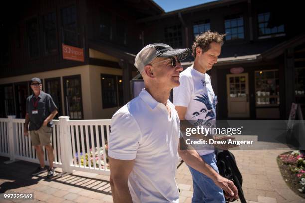 Jeff Bezos, chief executive officer of Amazon, and John Elkann, chairman of Fiat Chrysler Automobiles, walk together during the annual Allen &...