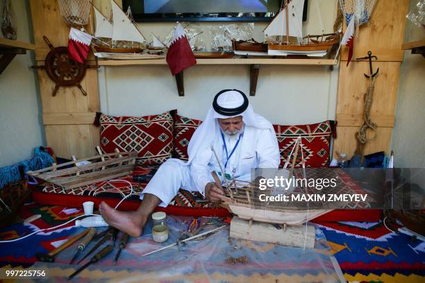 Qatar artist makes a Dhow boat in Majlis Qatar pavilion in Moscow's Gorky Park in Moscow on July 12, 2018. - Qatar will host of the FIFA World Cup in...