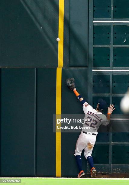 Josh Reddick of the Houston Astros is unable to make a play on a ball hit by Mark Canha of the Oakland Athletics in the eighth inning that scores two...