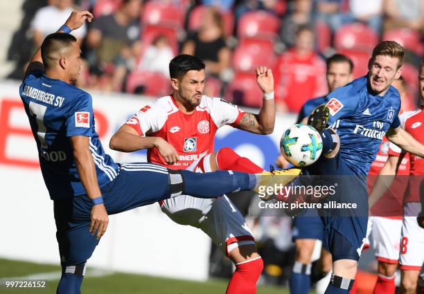 Mainz's Danny Latza and Hamburg's Bobby Wood and André Hahn vie for the ball during the German Bundesliga soccer match between 1. FSV Mainz 05 and...