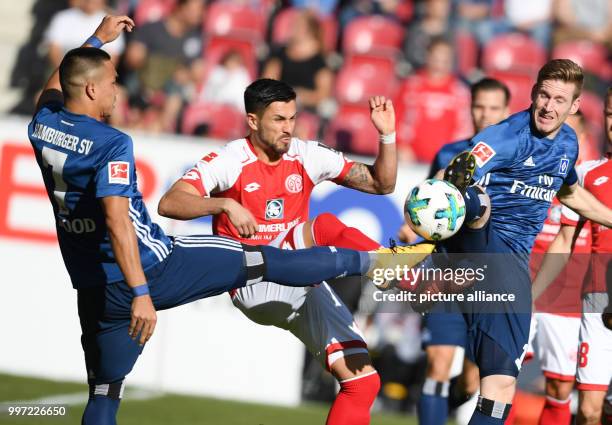 Mainz's Danny Latza in action against Hamburg's Bobby Wood und André Hahn during the German Bundesliga soccer match between 1. FSV Mainz 05 and...