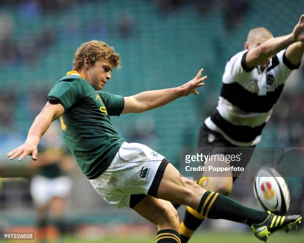 Patrick Lambie of South Africa kicks clear despite the attention of Drew Mitchell of the Barbarians during the Mastercard Trophy match between the...