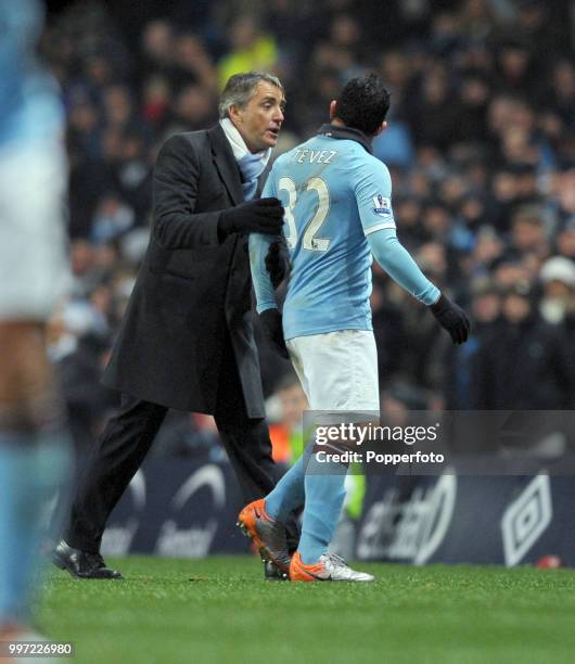 Carlos Tevez of Manchester City argues with manager Roberto Mancini after being substituted during the Barclays Premier League match between...