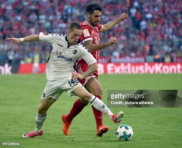 Freiburg's Ryan Kent and Bayern Munich's Javier Martinez battle for the ball during the German Bundesliga soccer match between FC Bayern Munich and...