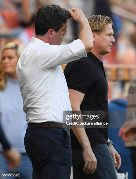 Hamburg's sport director Jens Todt touching his head beside coach Markus Gisdol during the German Bundesliga soccer match between 1. FSV Mainz 05 and...